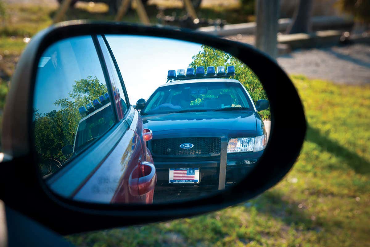 Police car reflected in another car's wing mirror