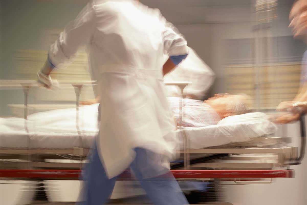 A person in a bed being pushed through hospital