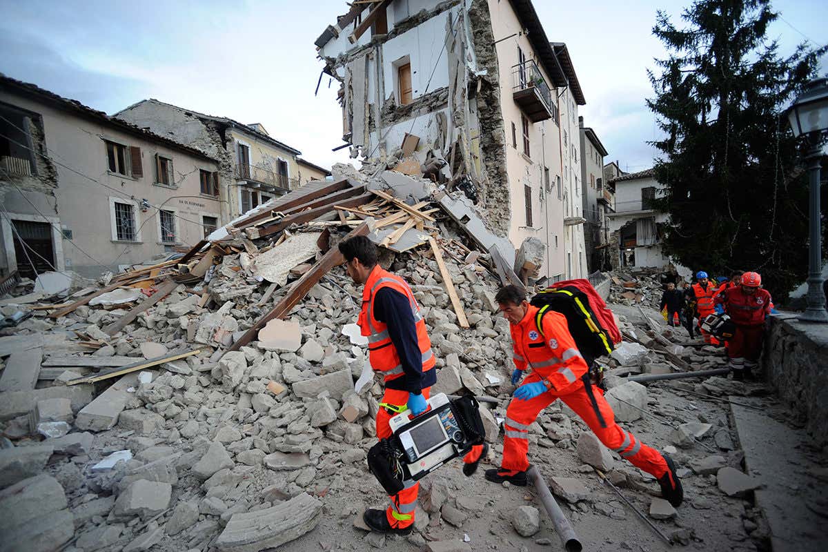Rescuers search a crumbled building in Arcuata del Tronto