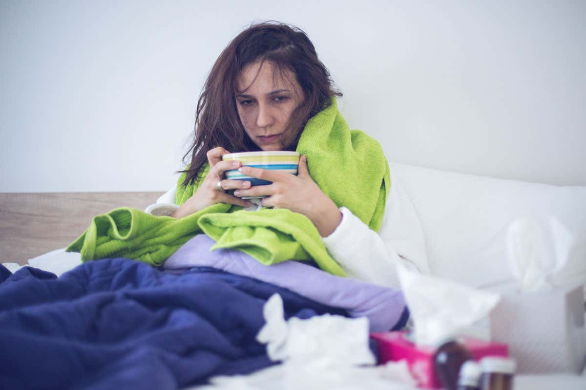 Woman in bed looking ill with cold or flu
