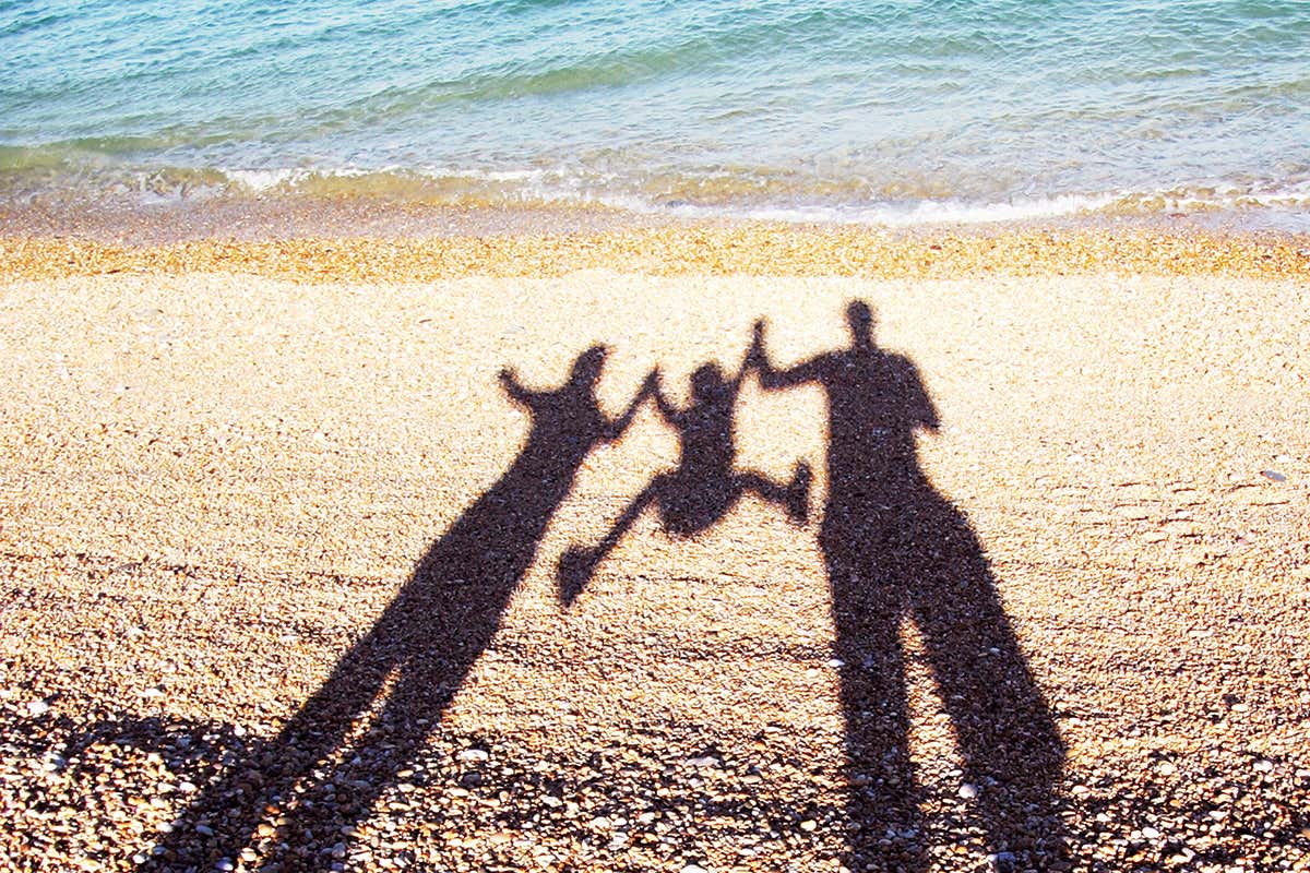 Shadow of a family swinging a child