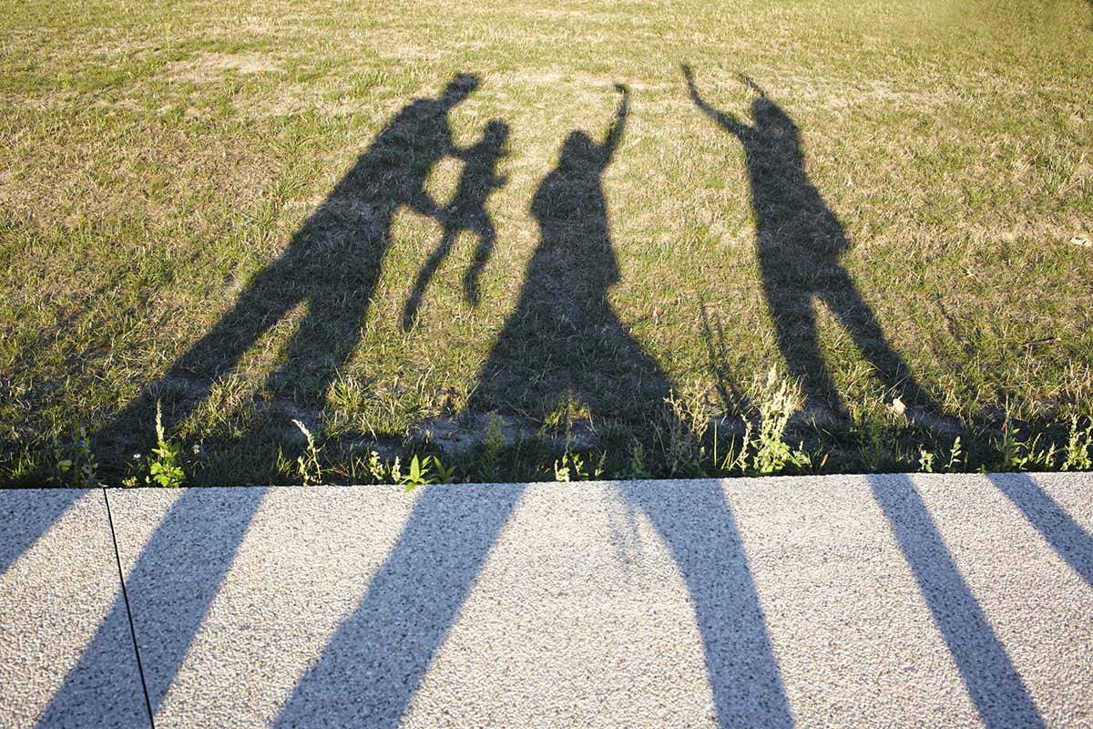 Shadows of 3 adults with a child
