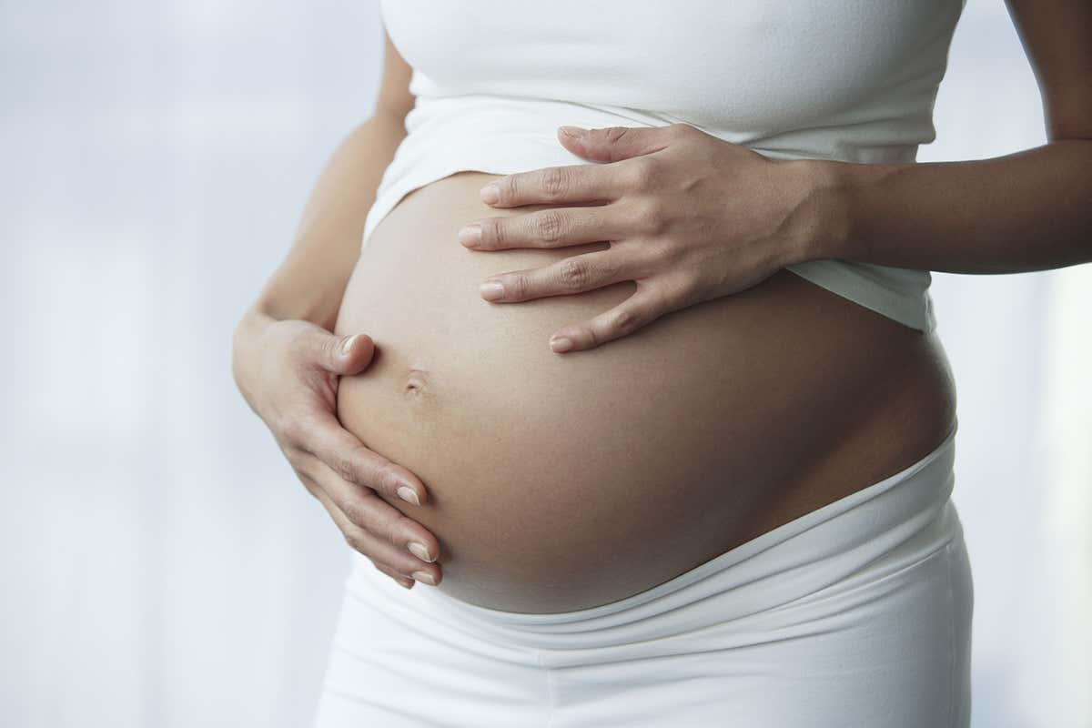 A pregnant woman touching her belly