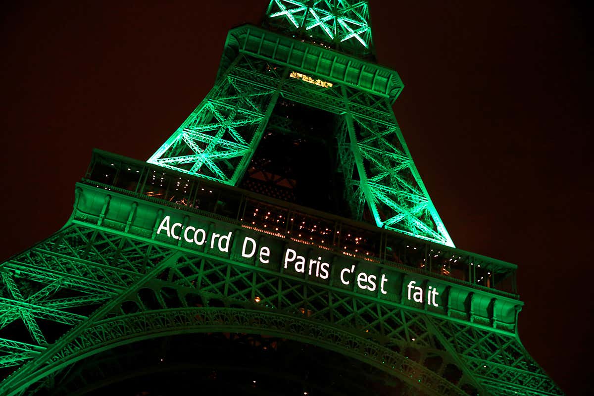 The Eiffel tower is illuminated in green with the words
