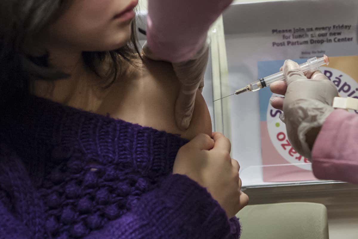 A woman in a doctors surgery getting a vaccination