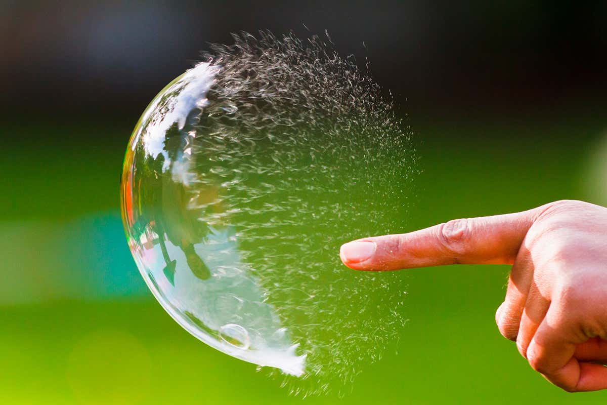 Finger pointing at a soap bubble