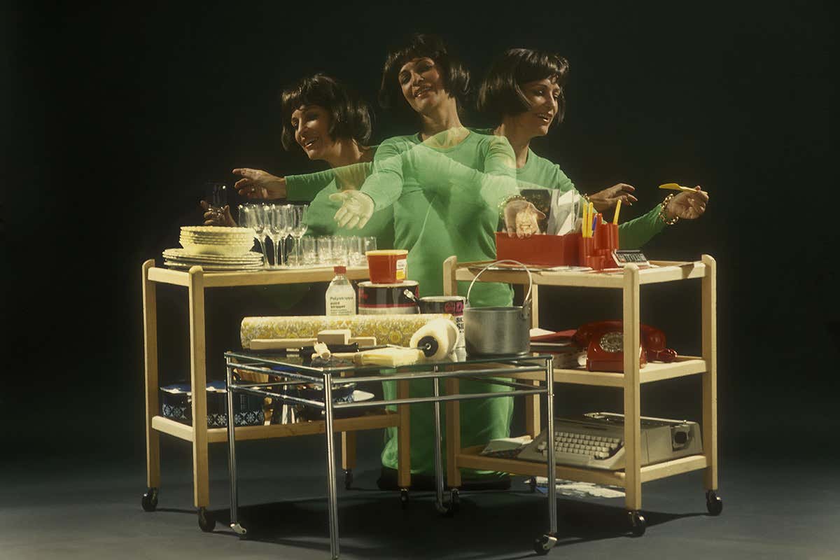 A woman flits between three tables of vintage items