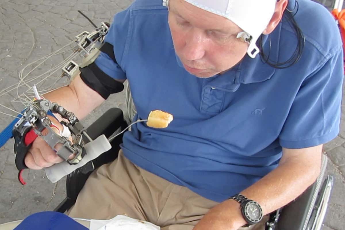 Paralysed man eating with robotic exoskeleton