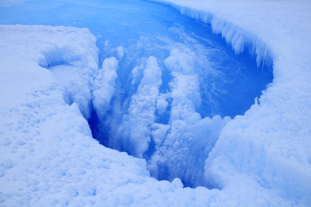 A well-like formation in the ice with water flowing into it
