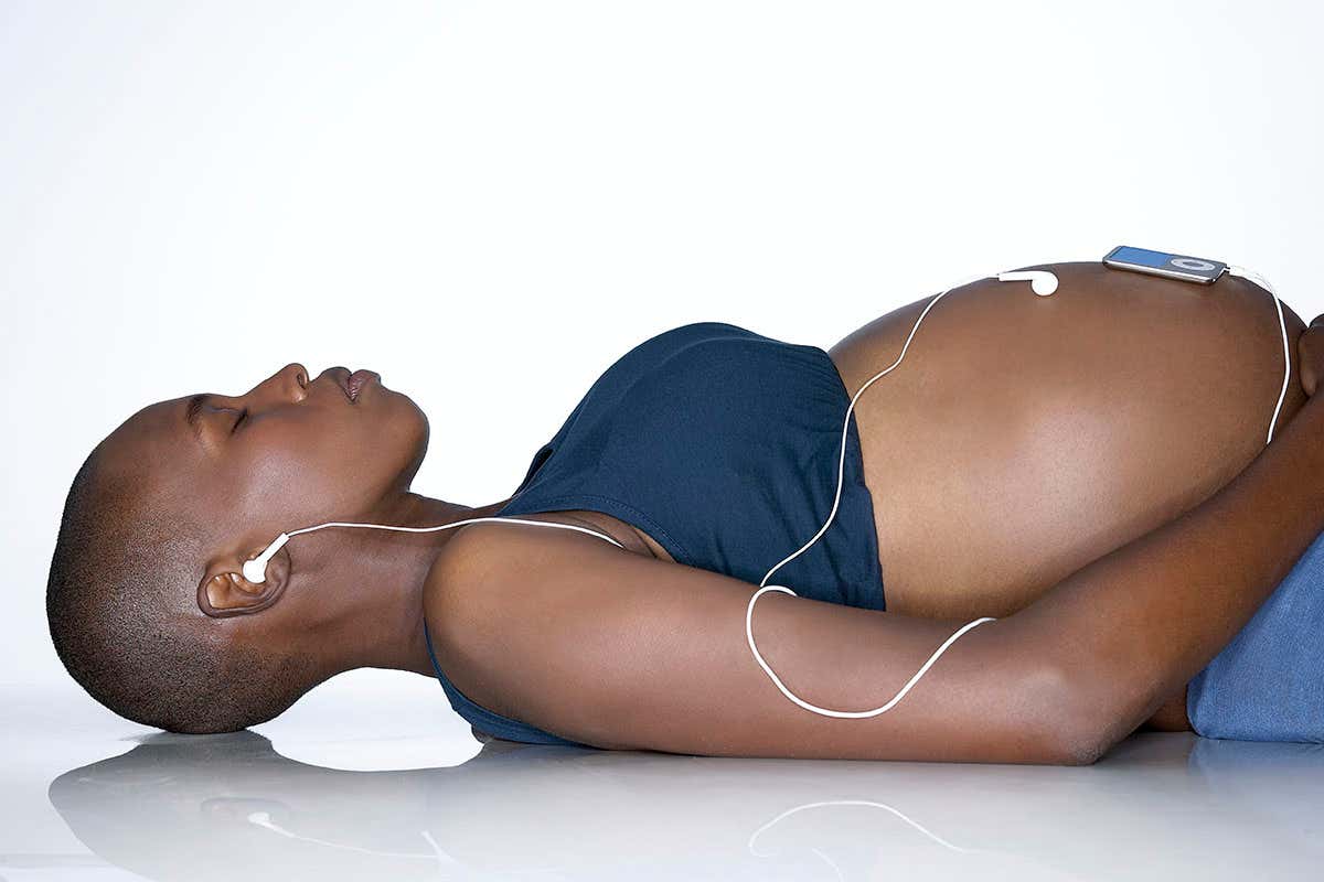 Pregnant woman listening to music on iPod