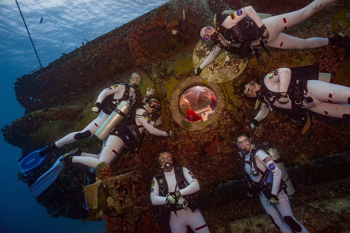 Aquanauts cluster around Aquarius vessel