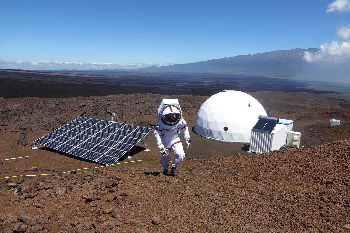 Sheyna Gifford in spacesuit walking up a slope
