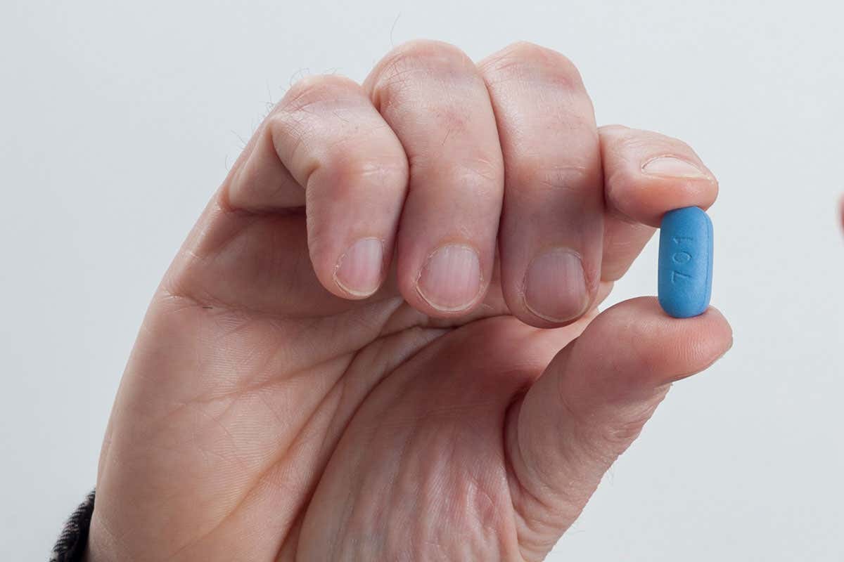 Hand holding PrEP pill