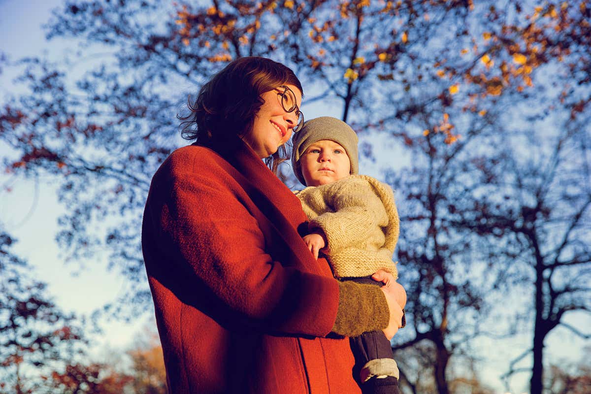 Mother holding young child on her left side