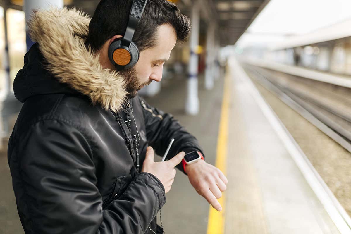 Man wearing smartwatch at train station