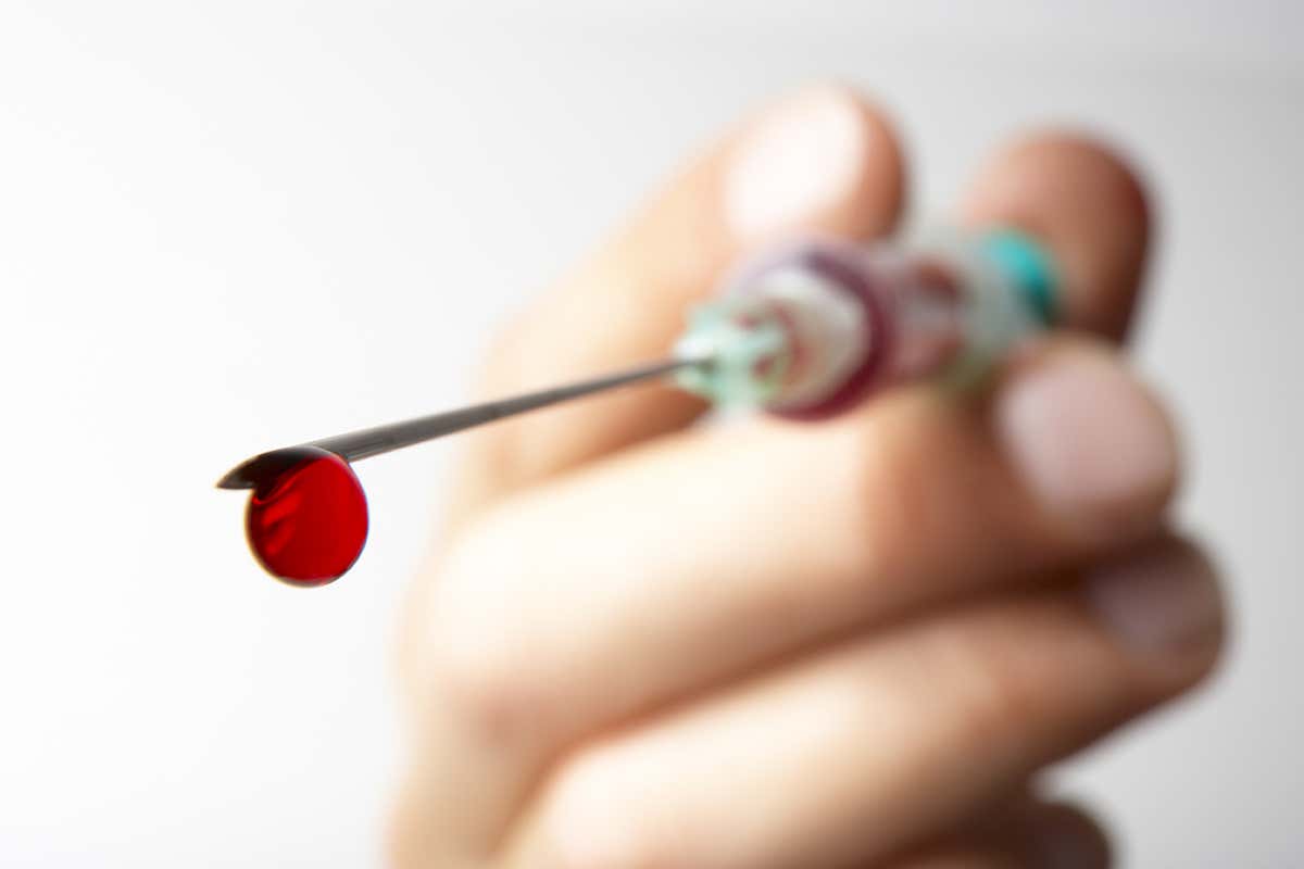 A drop of blood coming out of a needle