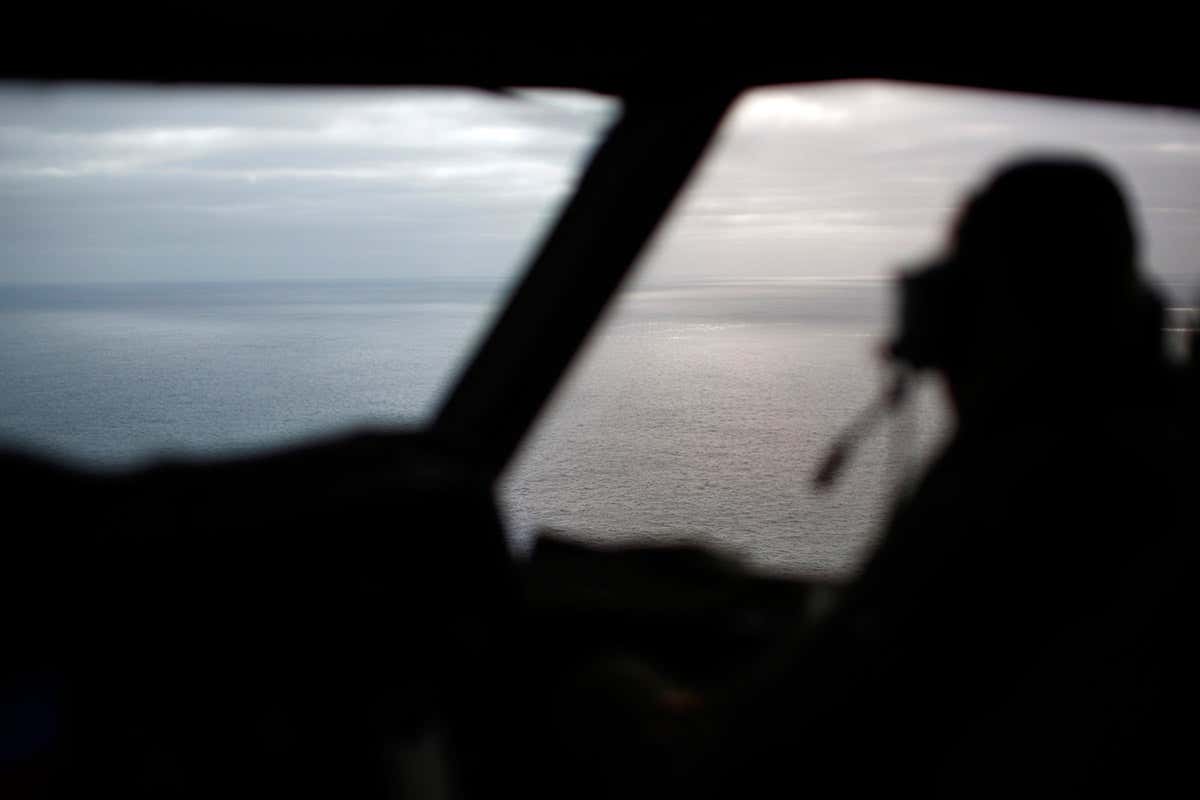 Cockpit shot of pilot looking out at ocean