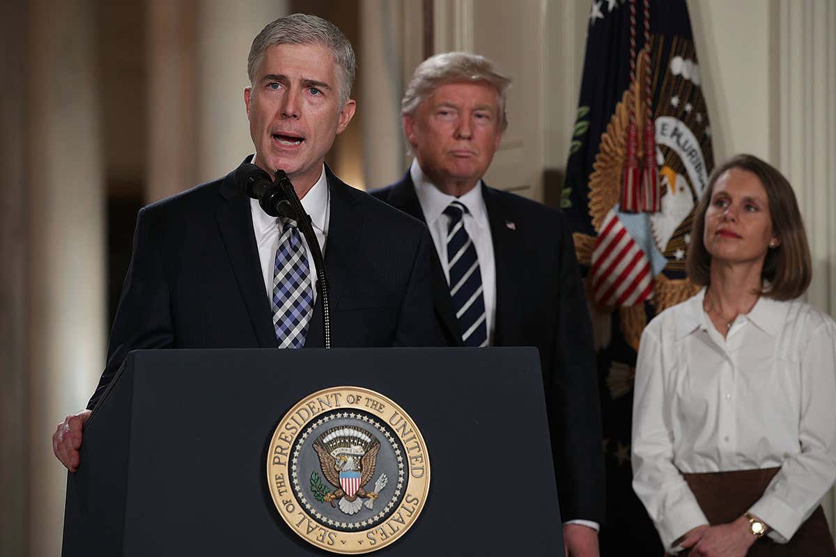Neil Gorsuch at podium with Trump in background