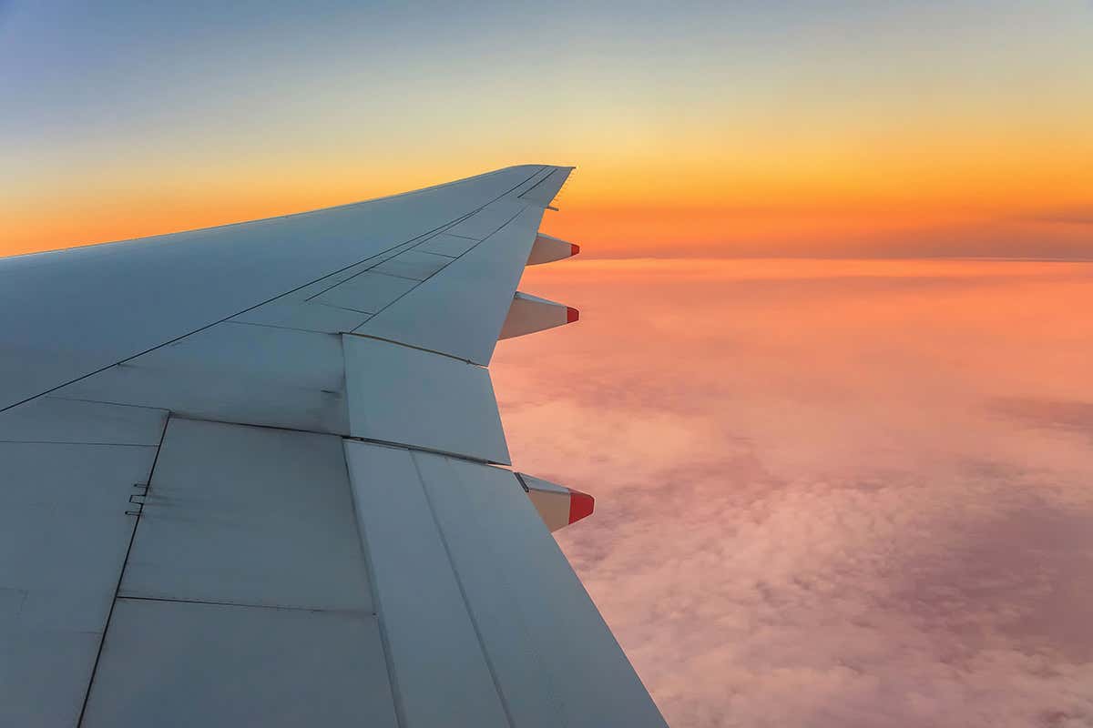 Aircraft's wing with rosy horizon beyond