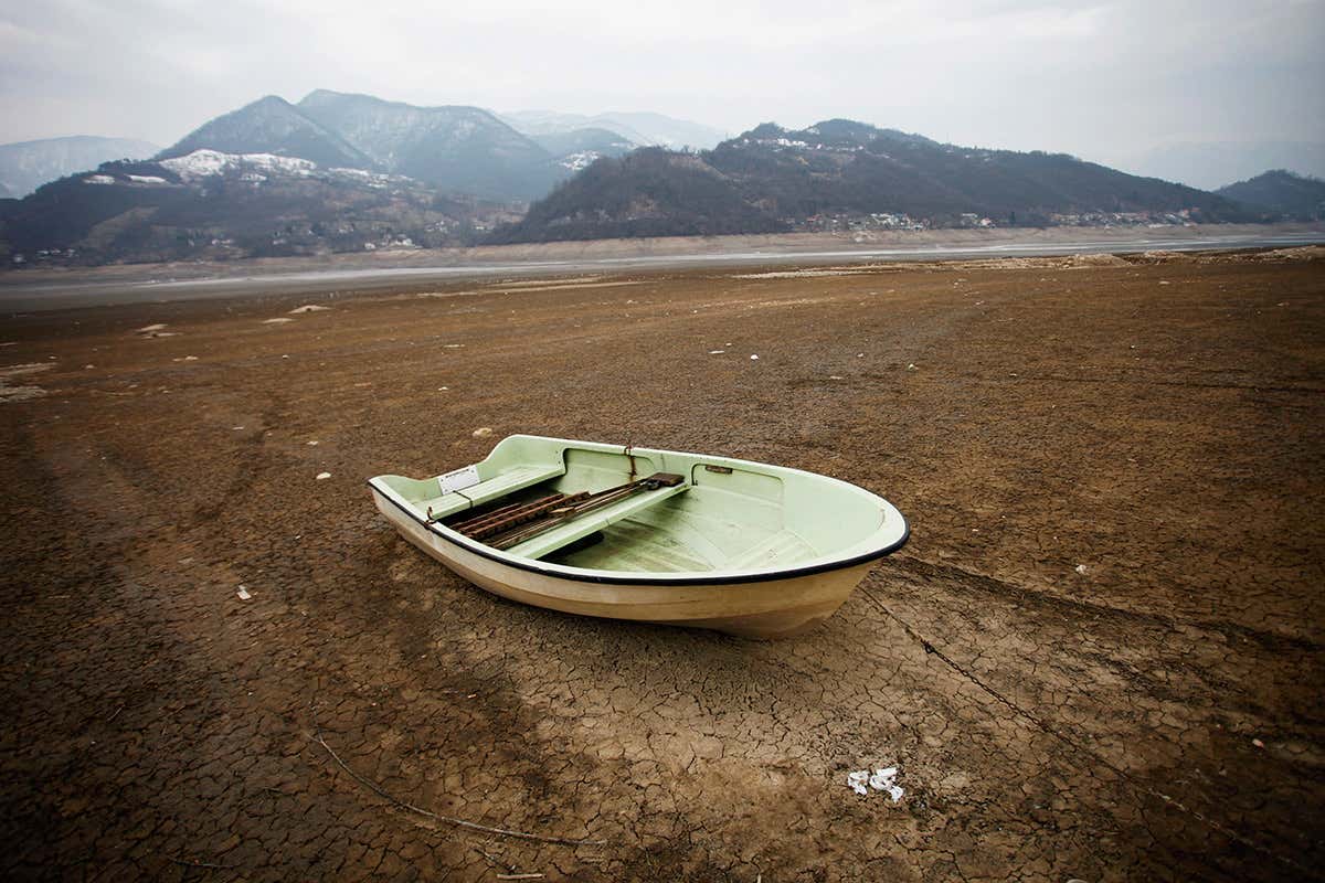 Boat on dried-up lake floor