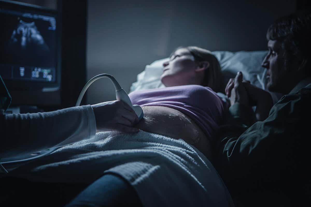 Woman is having her stomach scanned via ultrasound