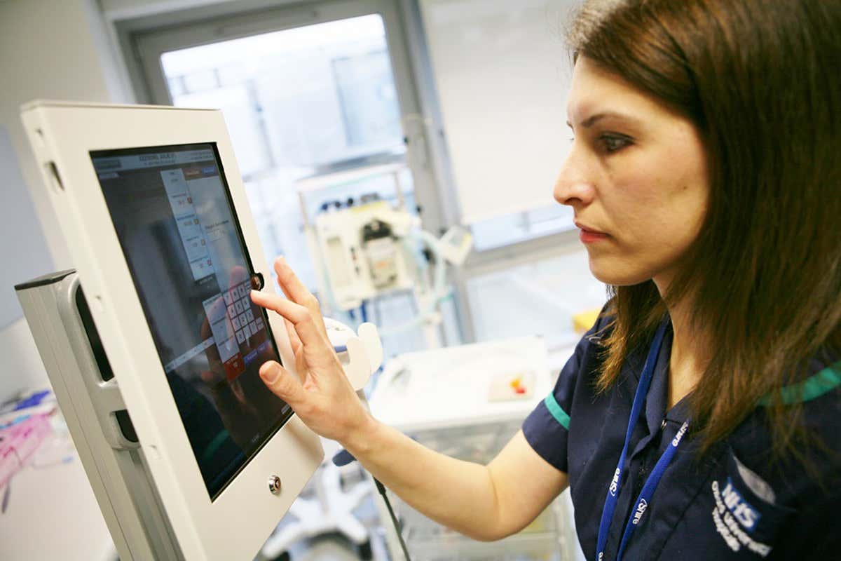 A nurse using the SEND medical app that sends early warning alerts based on patients' vital signs