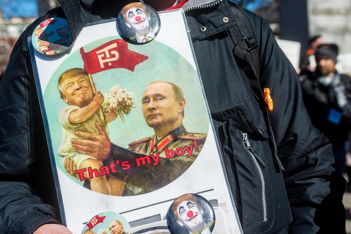 A poster with Donals Trump as a child in Vladimir Putin's arms with the text 