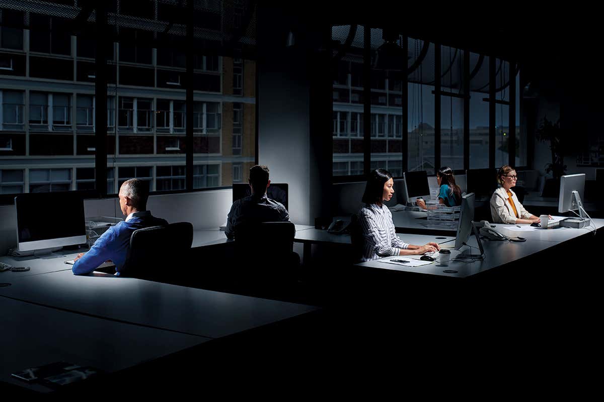 People at computers sitting in a darkened office