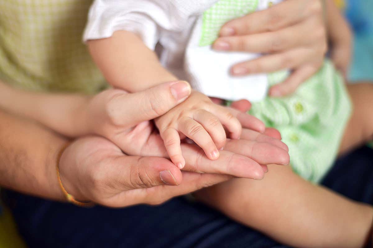 Hands of parents and a baby