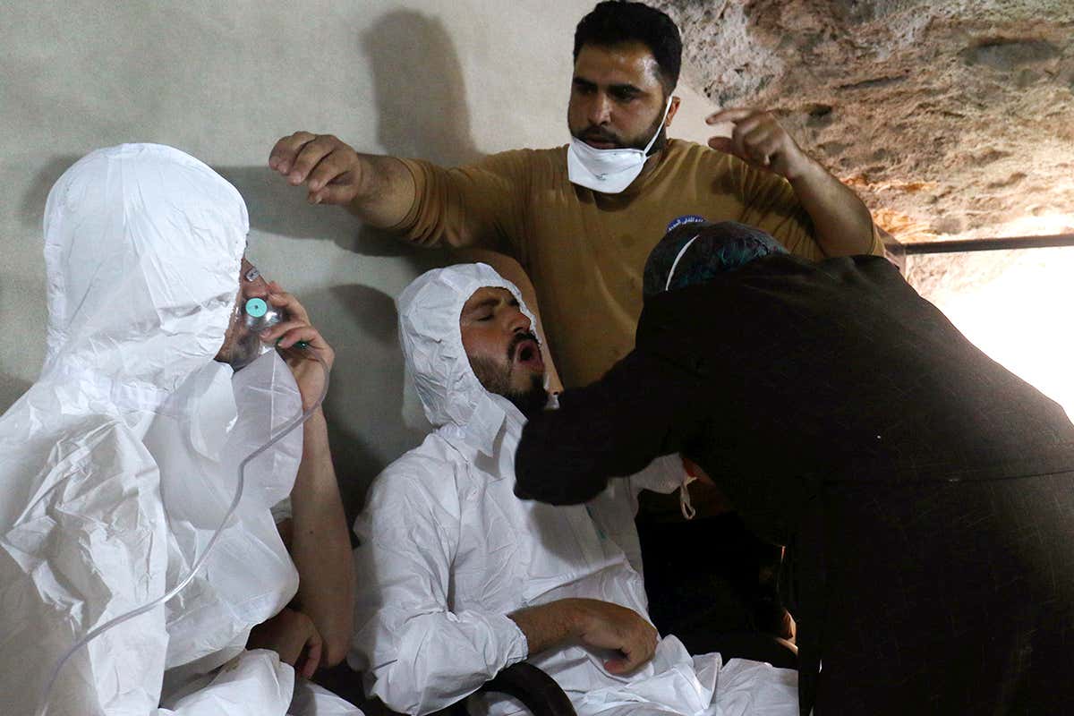 People in white suits receive medical treatment