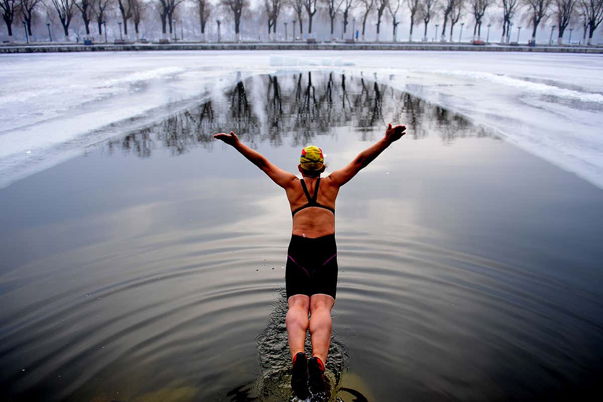 A swimmer diving into an icy lake
