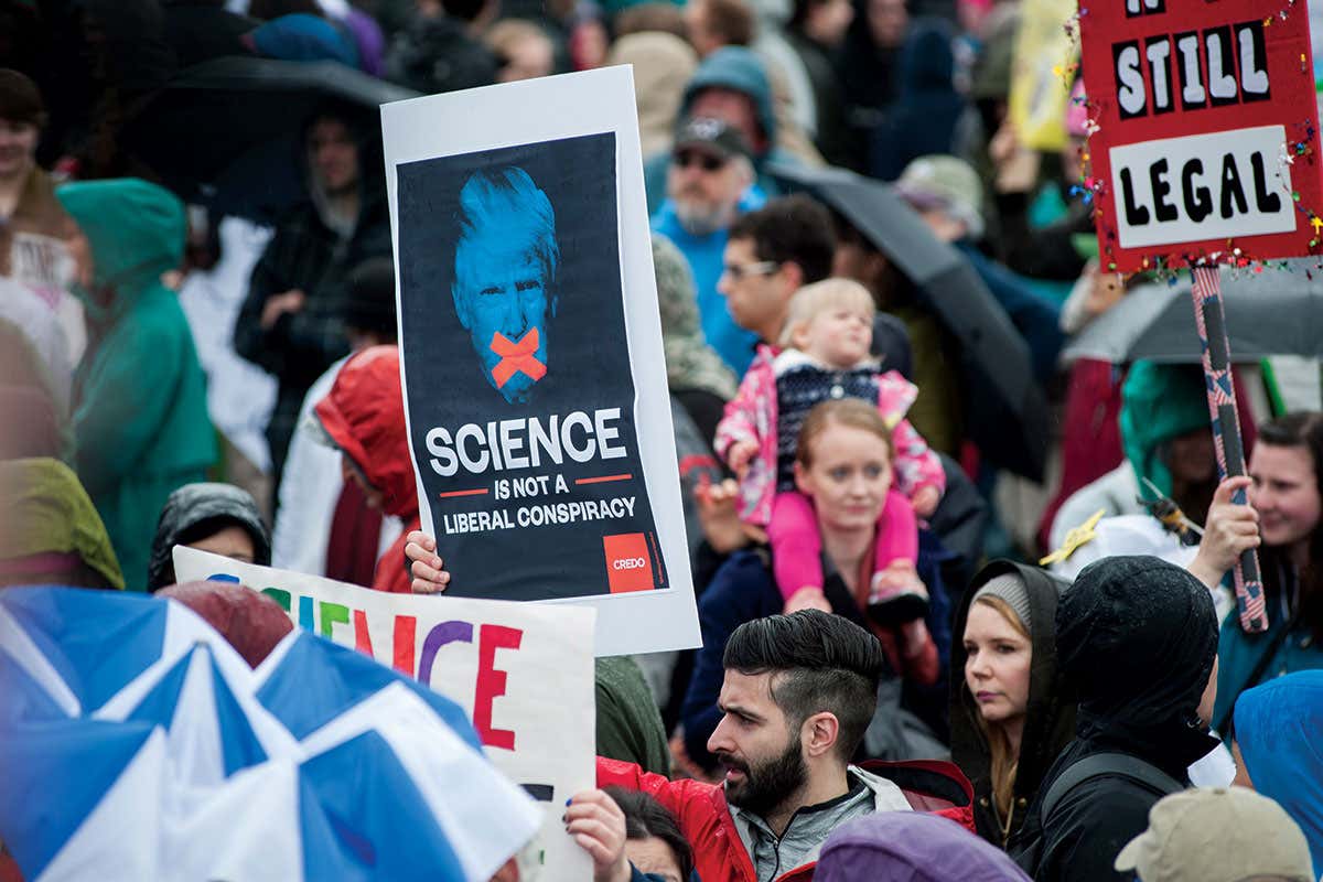 Person holds placard reading 