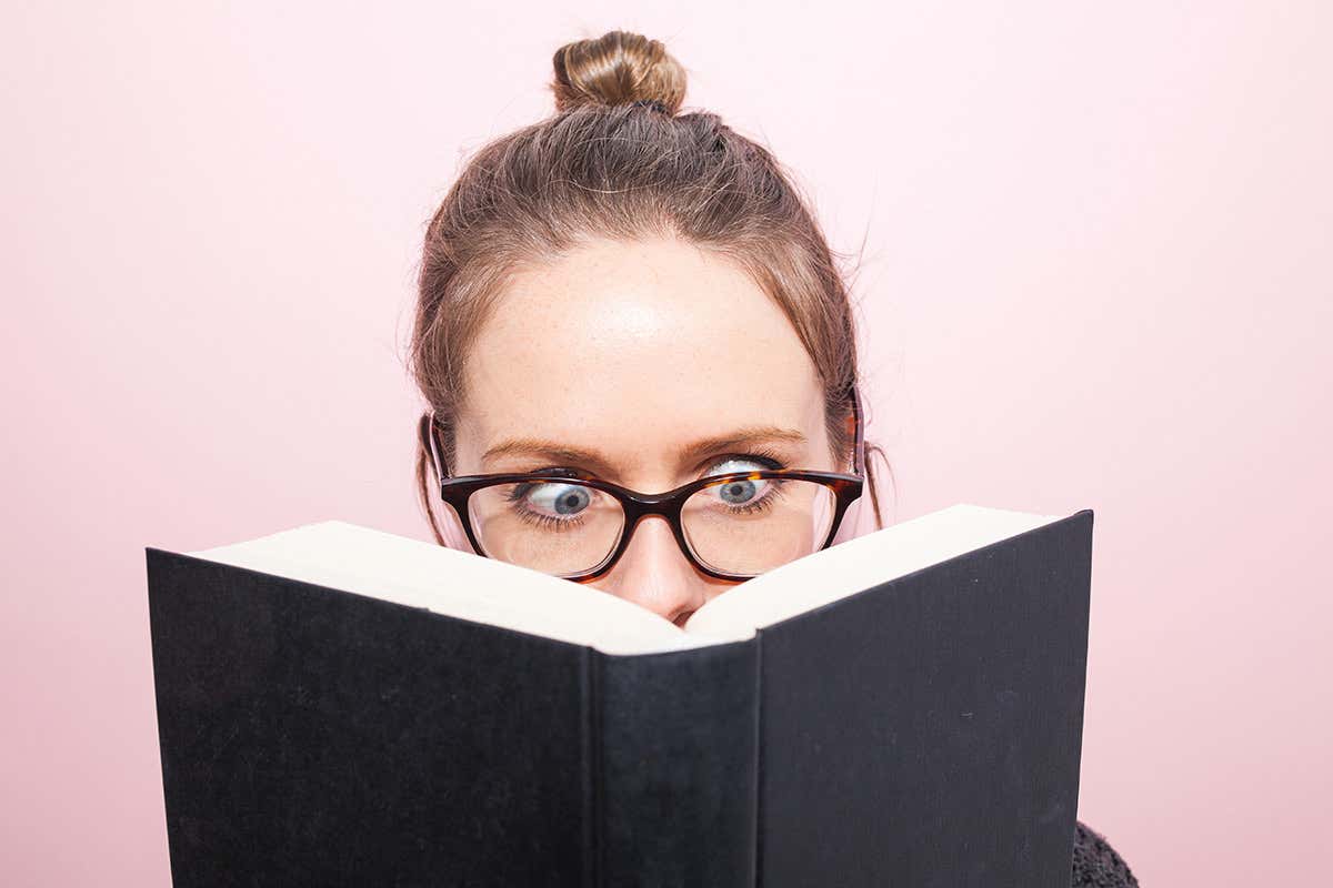 A woman wearing glasses reading a book