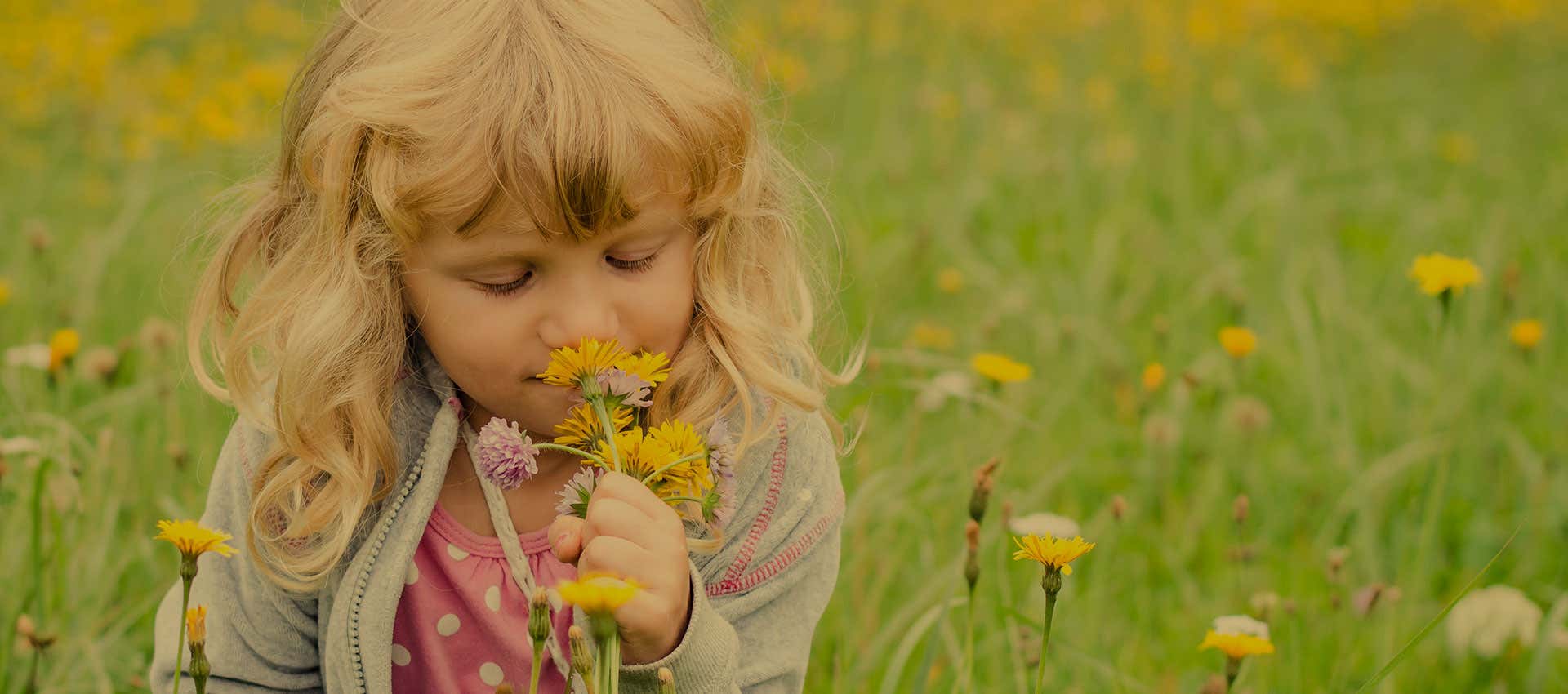 child smelling flower