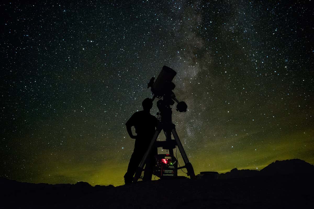 Astronomer looking through telescope