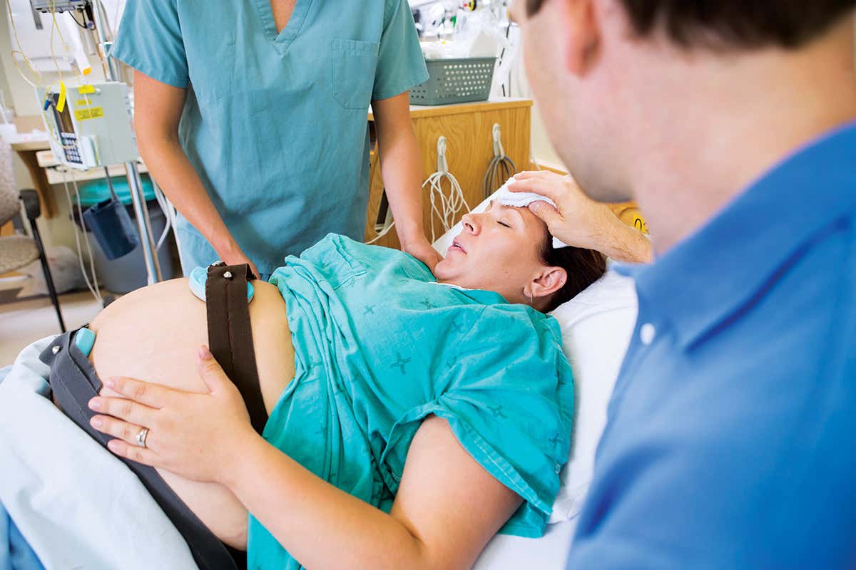 A pregnant woman receives treatment in hospital