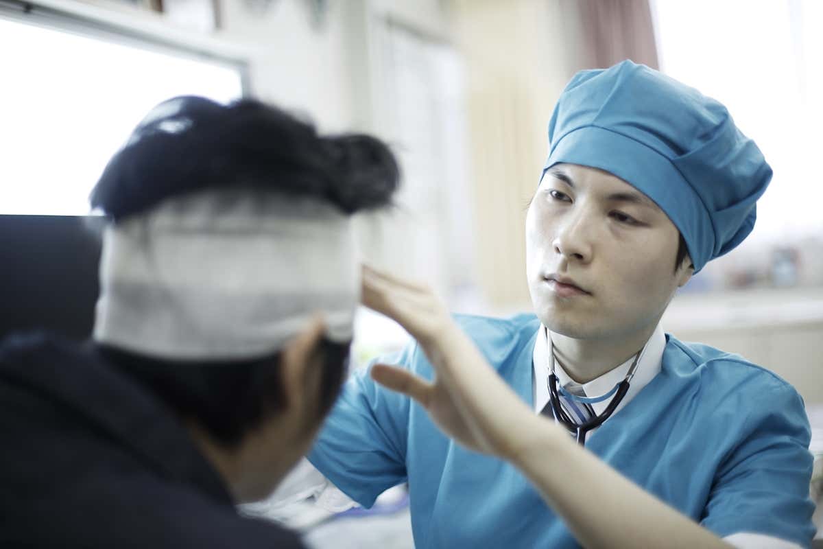 person having their head bandaged