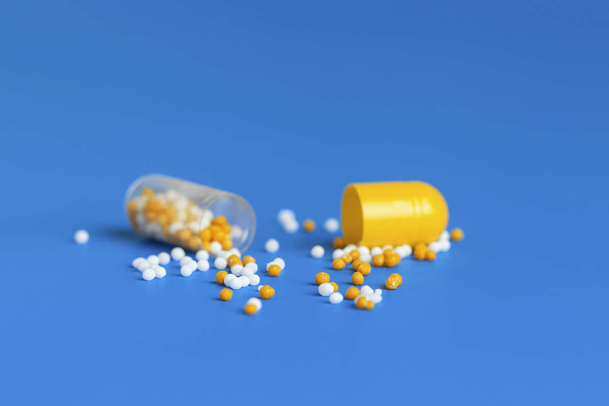 open drug capsule with beads falling out