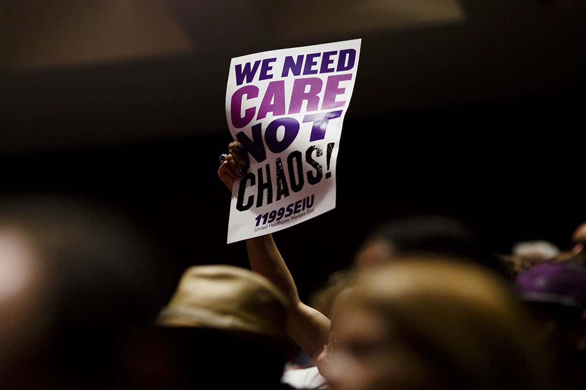 Person in a crowd holding a sign that says