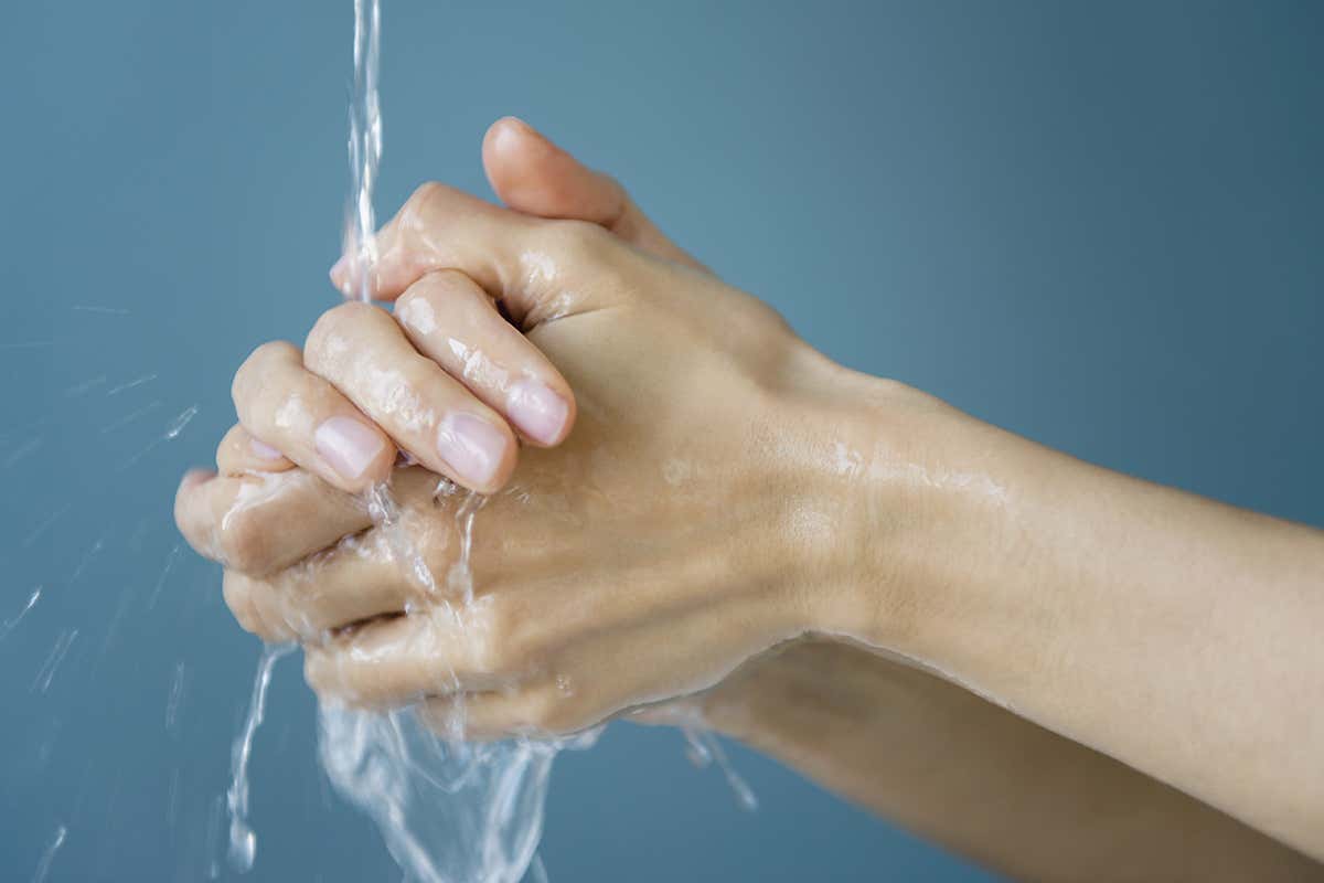 Hands being washed under a running tap