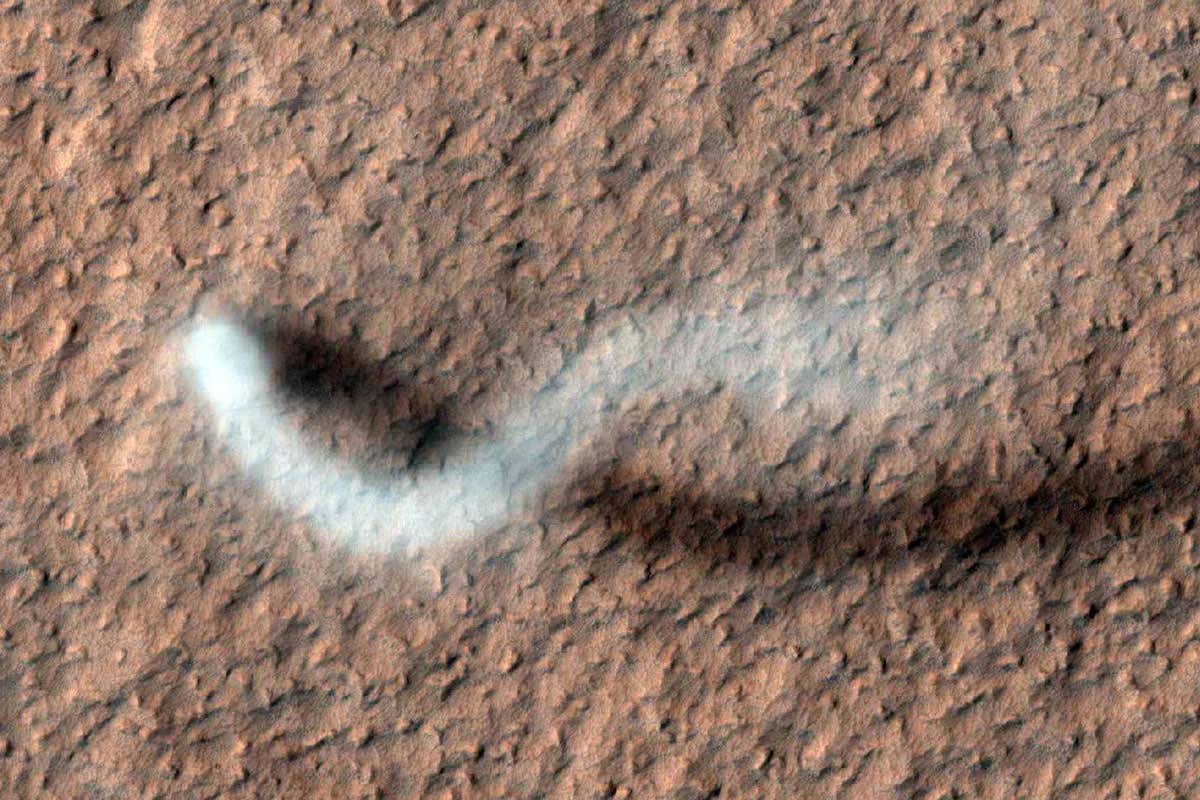 A white dust devil against the red Martian surface