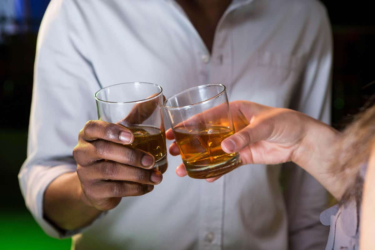 People clinking glasses of whisky