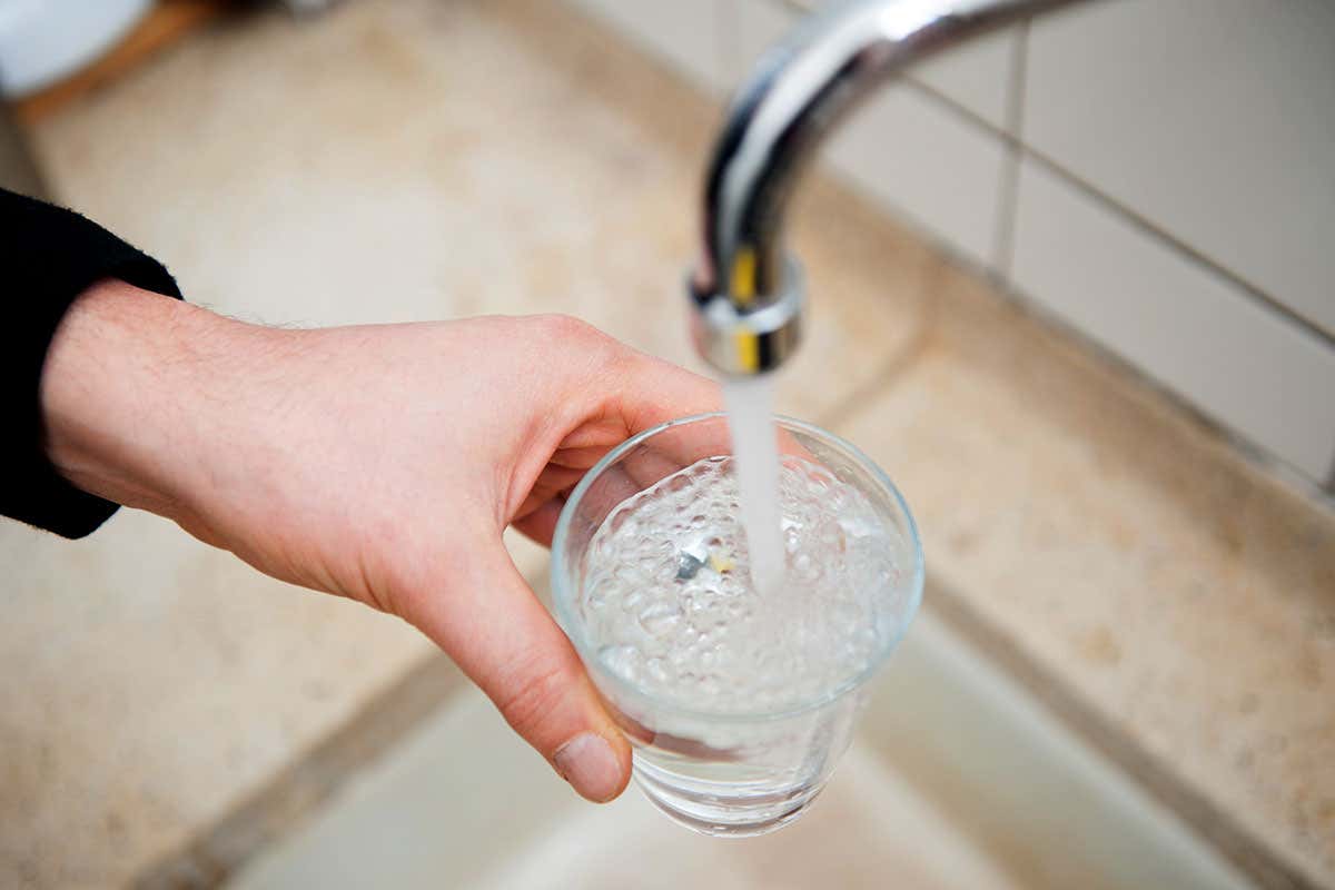 A person getting a glass of tap water