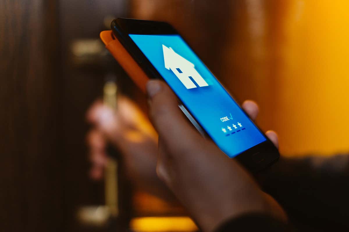 A woman opening the door of her house with a phone app