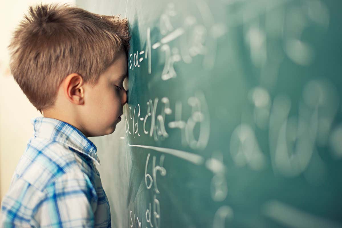 boy with blackboard covered in sums