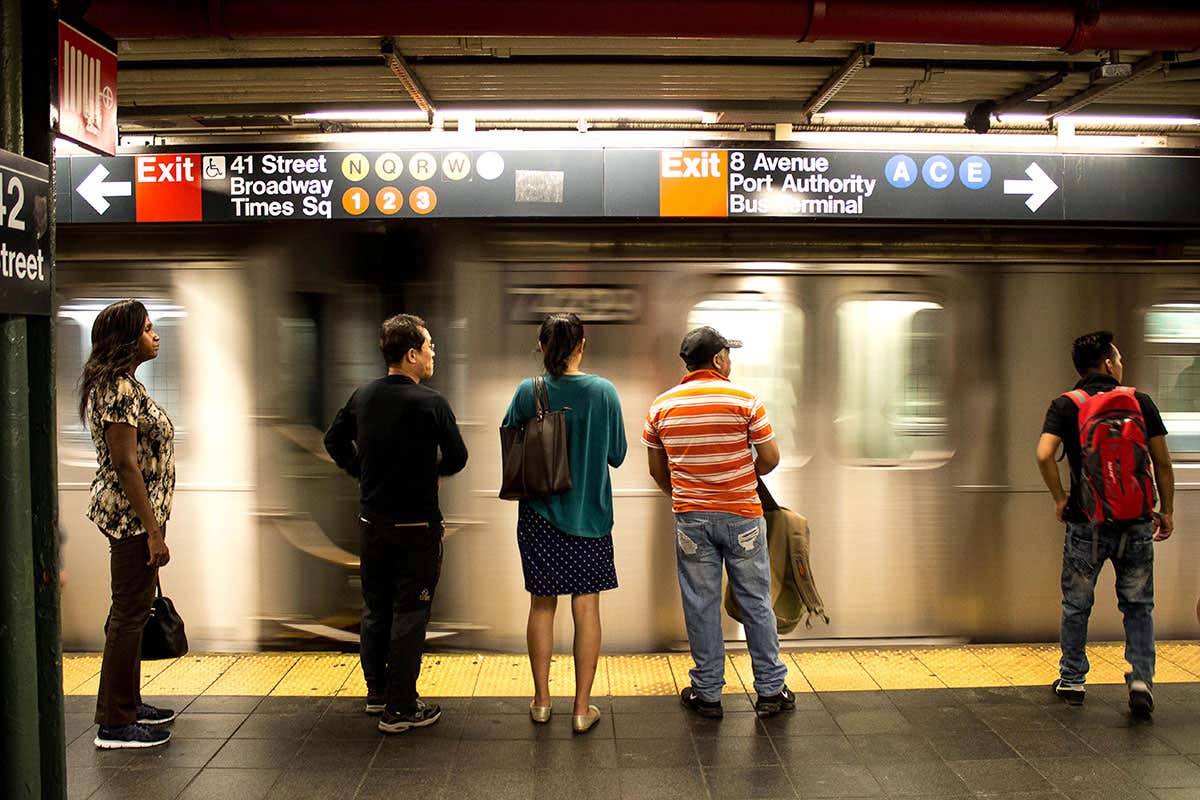 Commuters wait at NYC subway platform