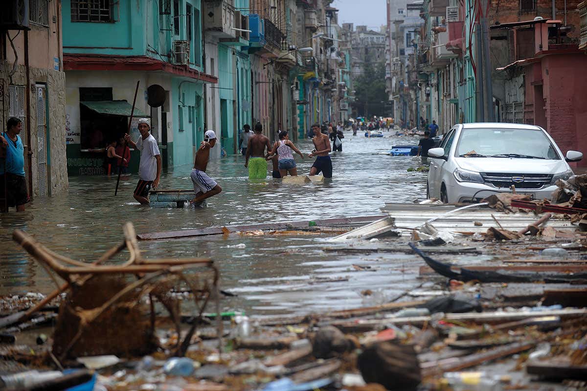Cubans wading through flood water