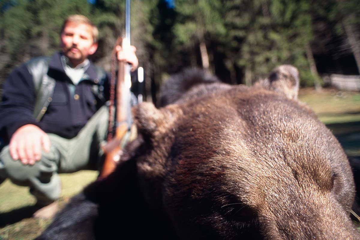 A hunter with a dead bear