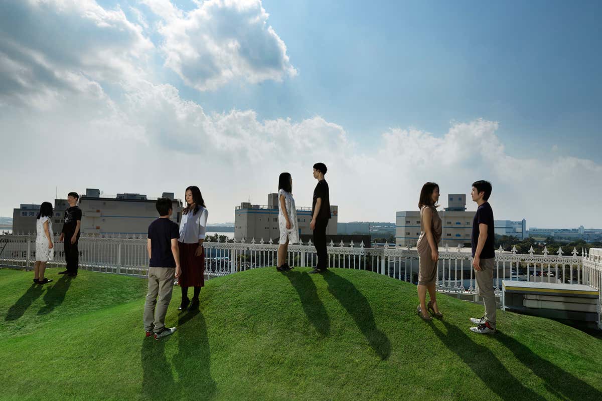 Four Japanese couples posed on a hilltop