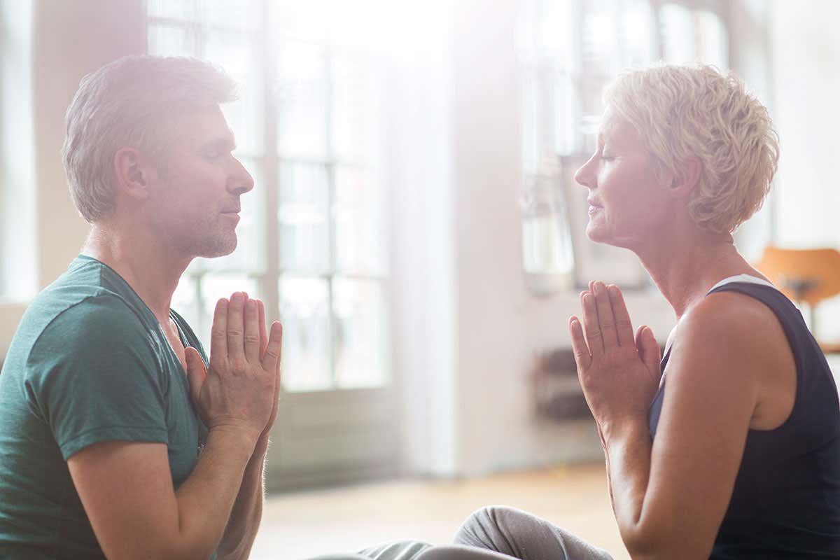 Two people meditate facing each other